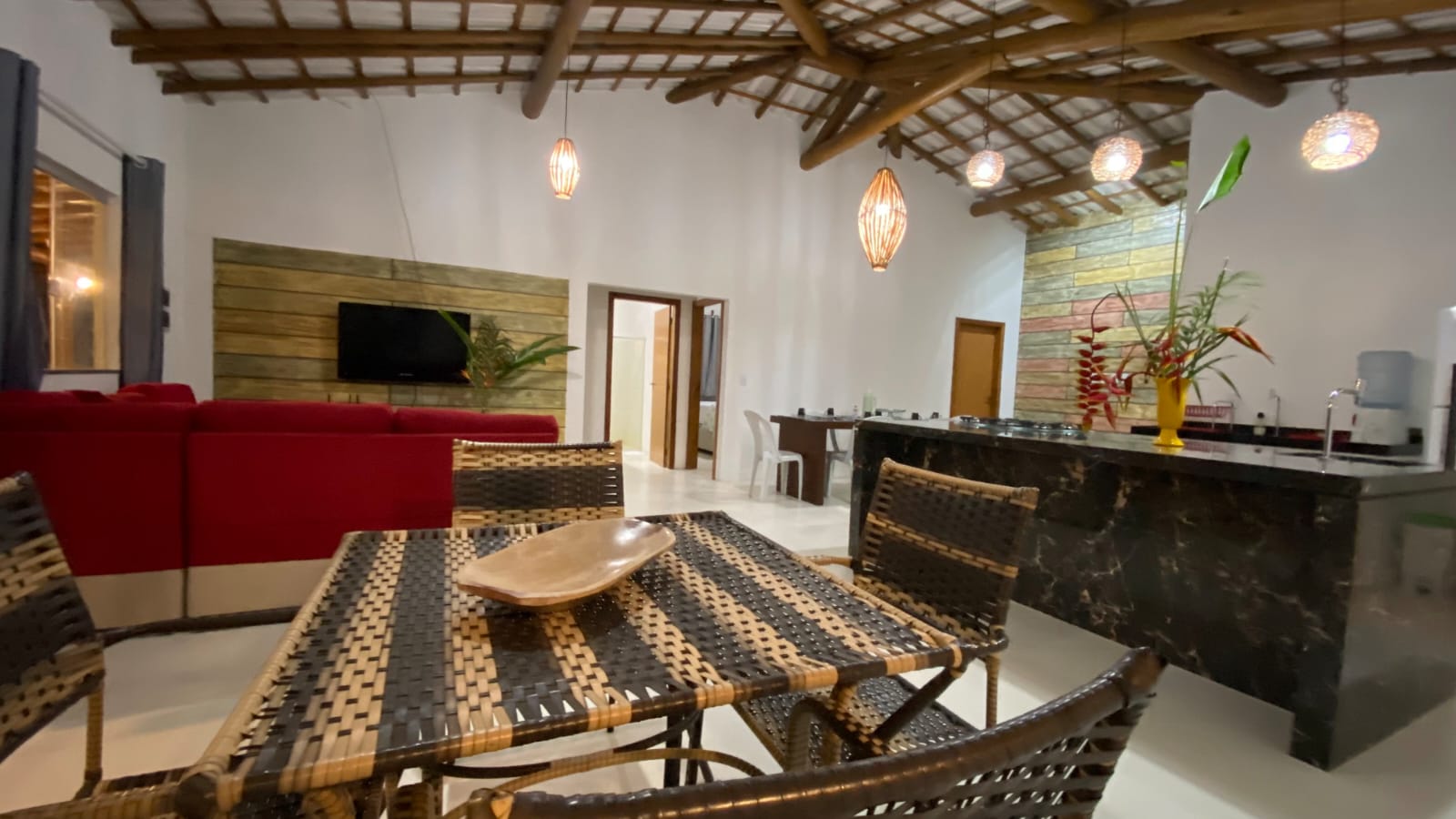 Sala e cozinha integradas com teto de madeira